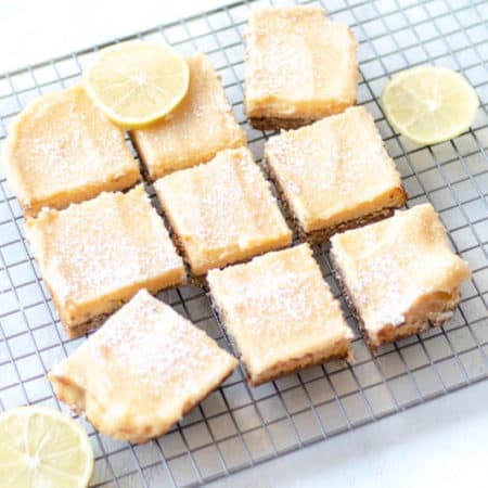 lemon passionfruit bars on cooling rack with lemon slices