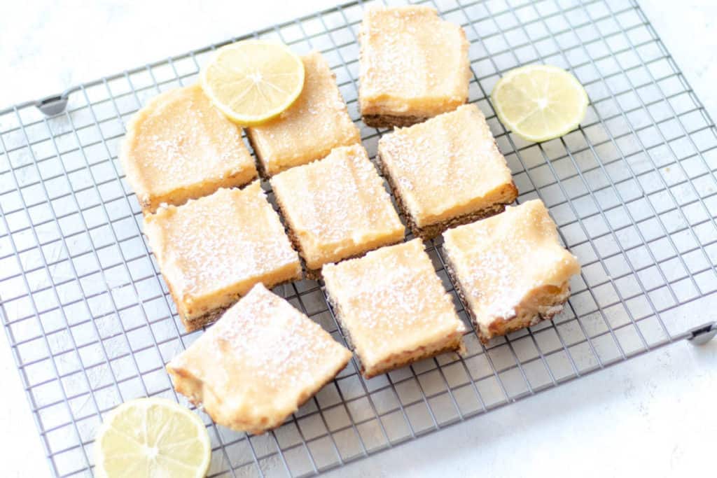 lemon passionfruit bars on cooling rack with lemon slices