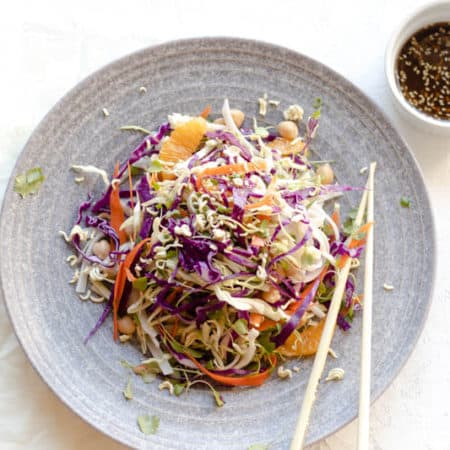 asian slaw salad in a bowl with chopsticks