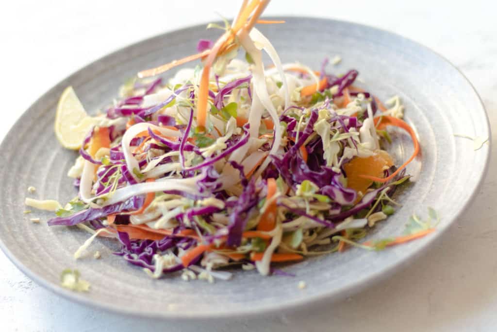 slaw salad being picked up with chopsticks