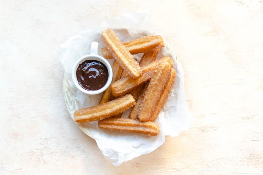 churros in a bowl with a side of chocolate sauce