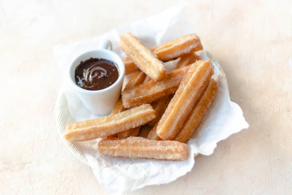 a bowl of churros with espresso chocolate sauce on the side