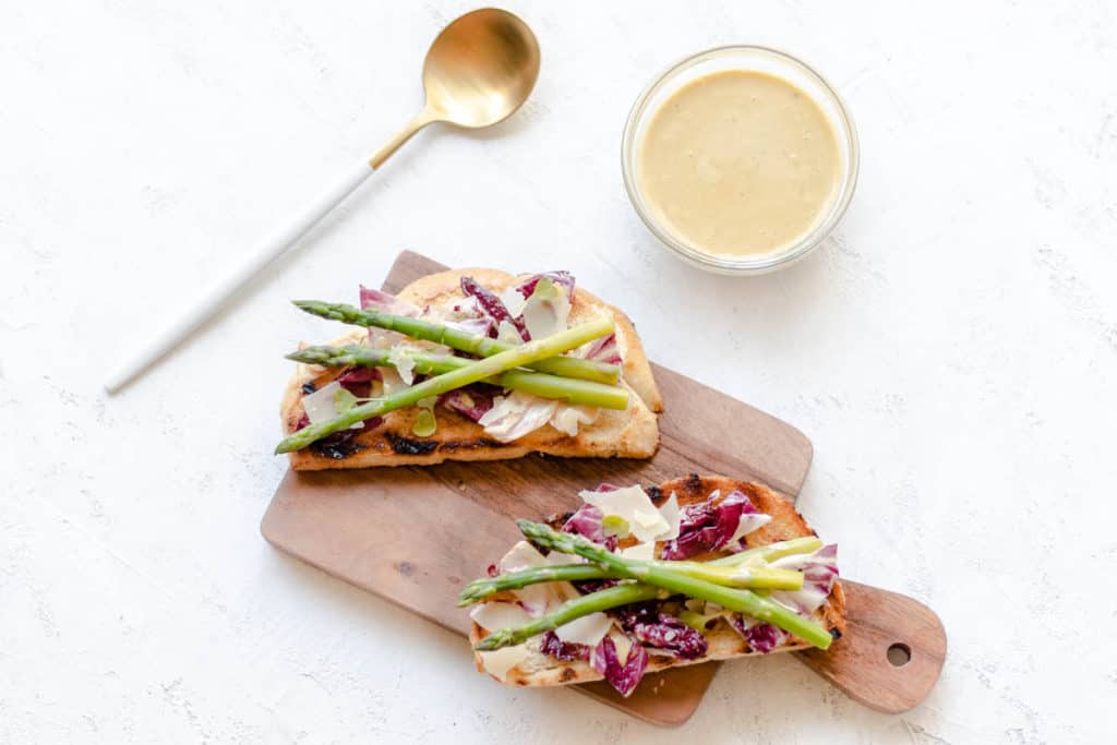 radicchio caesar asparagus toast on a mini cutting board