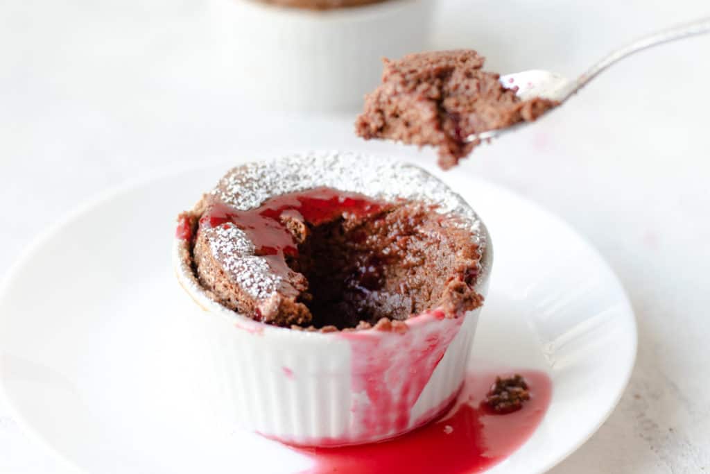 spoon scooping out some chocolate soufflé from a ramekin