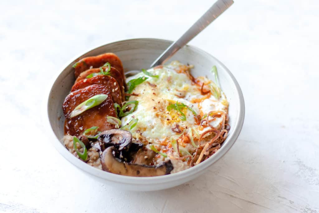 bowl of savory oats with a spoon inside
