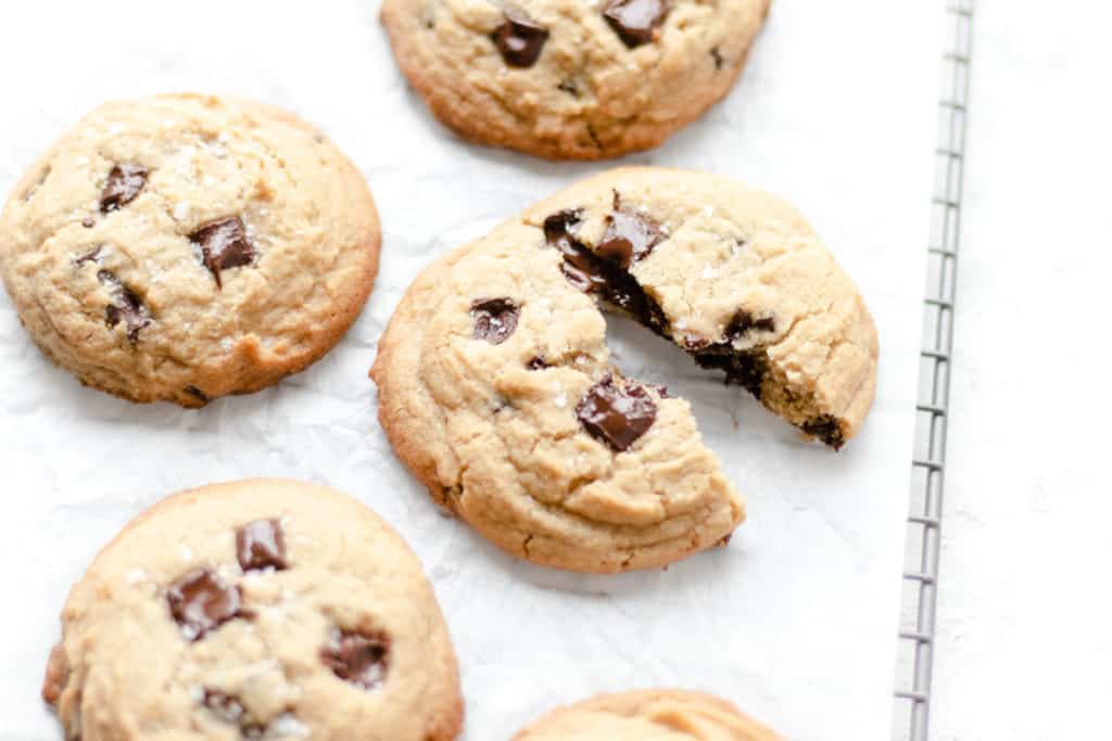 chocolate chip cookie with tahini split in half on parchment paper