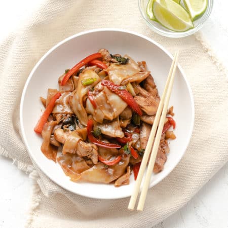 drunken noodles in a bowl with chopsticks