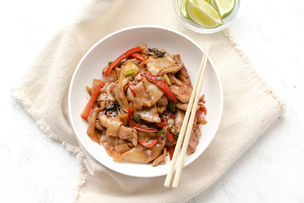 wide rice noodles with red bell peppers in a bowl 