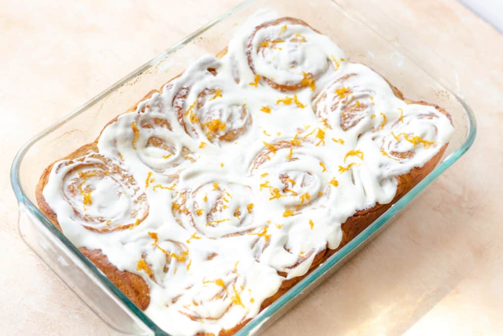 orange cinnamon rolls in a baking dish
