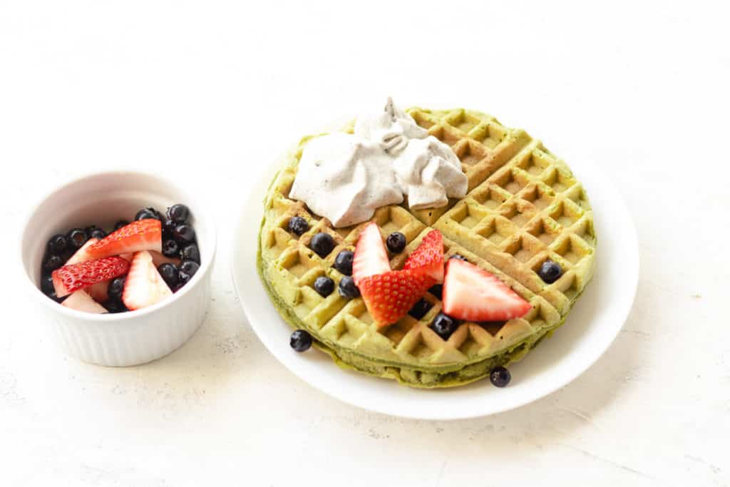 Plate of matcha waffles served with black sesame whipped cream