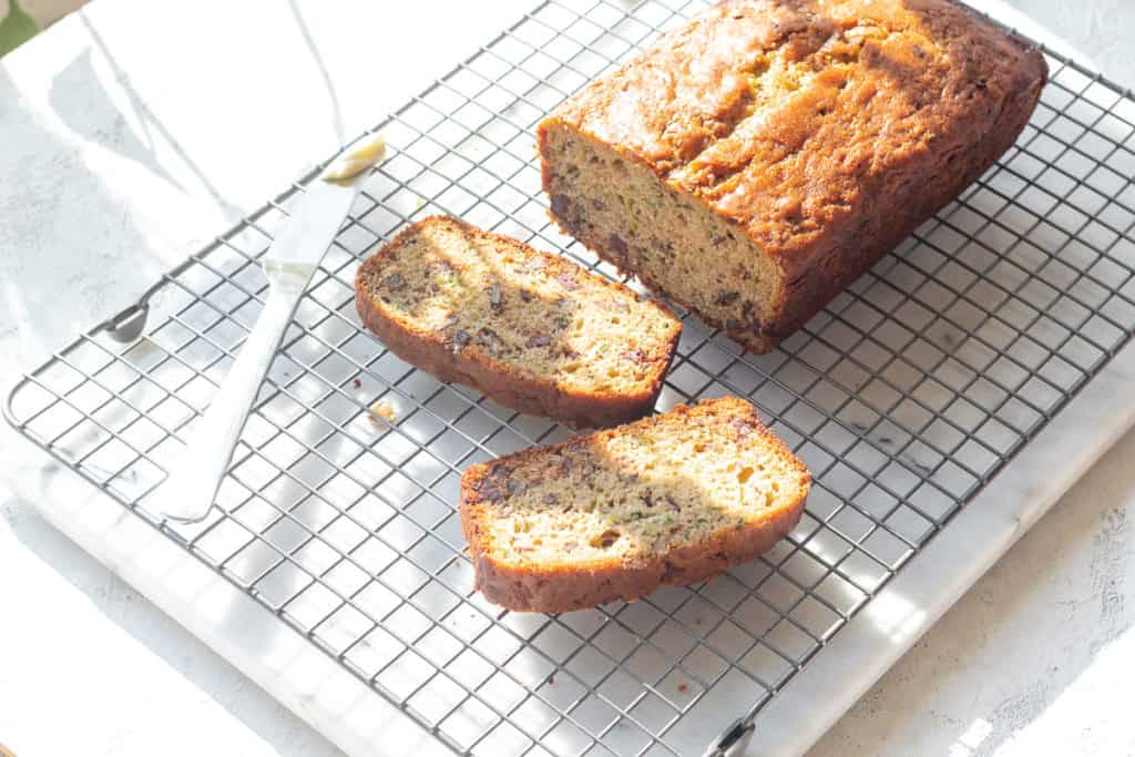 chocolate chip zucchini bread on a cooling rack with a butter knife