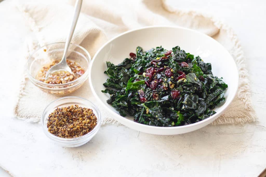 kale salad with cranberries and a side of crispy quinoa