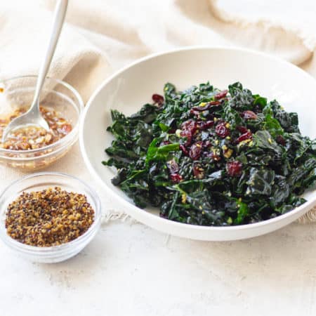 warm kale salad bowl with a side of pecan vinagrette