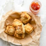 flaky golden biscuits in a bowl with a side of jam