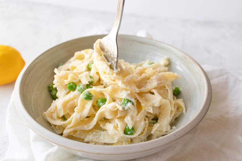lemon ricotta pasta with peas being twisted with a fork