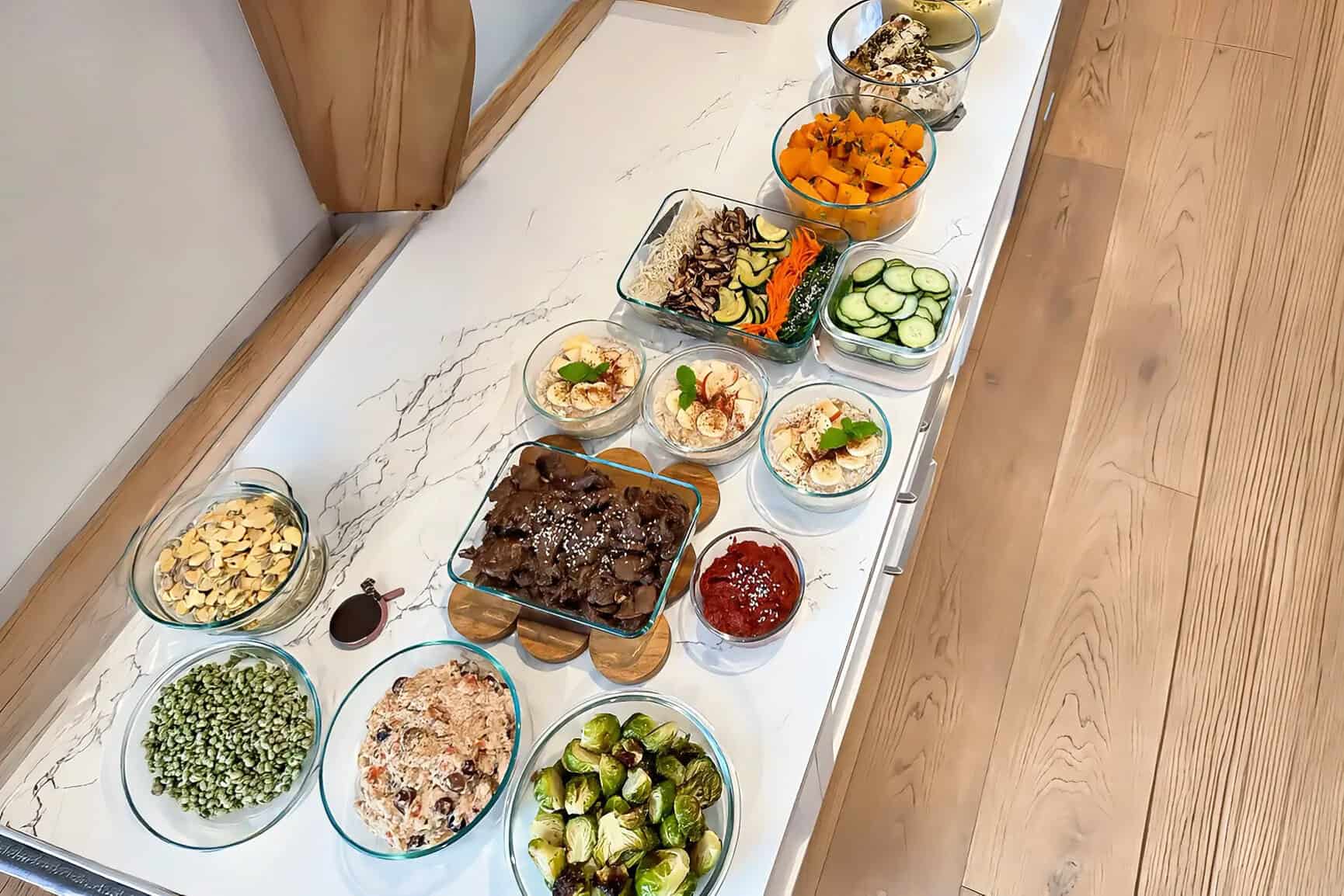 A full private chef cook day laid out on a Los Angeles kitchen island — dinners, breakfasts and sides in glass containers