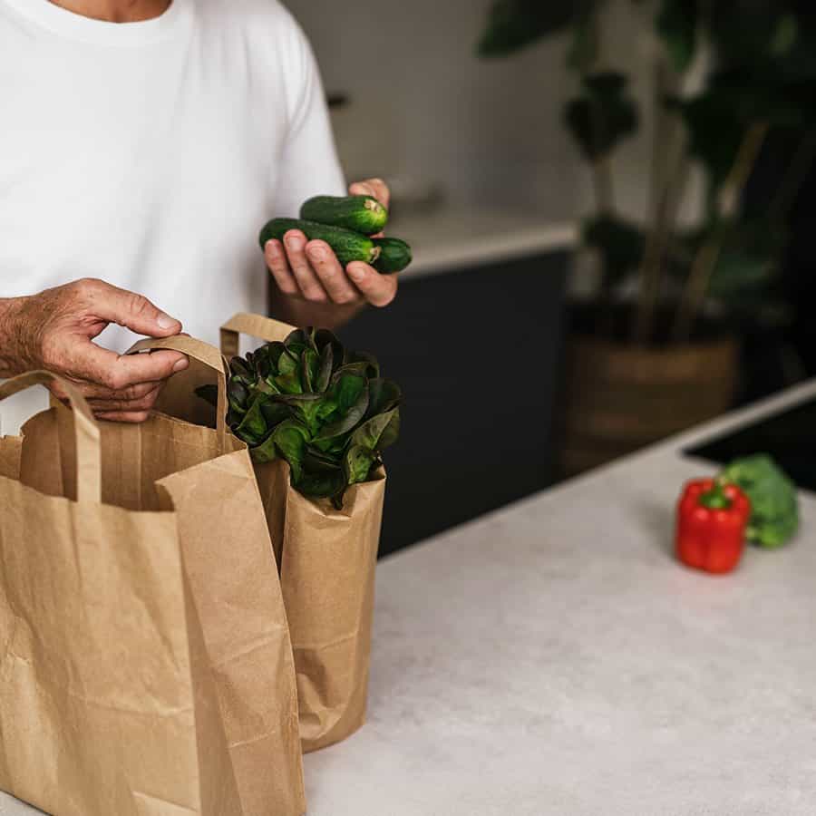 Fresh groceries in paper bags on a kitchen counter at the start of a private chef service day