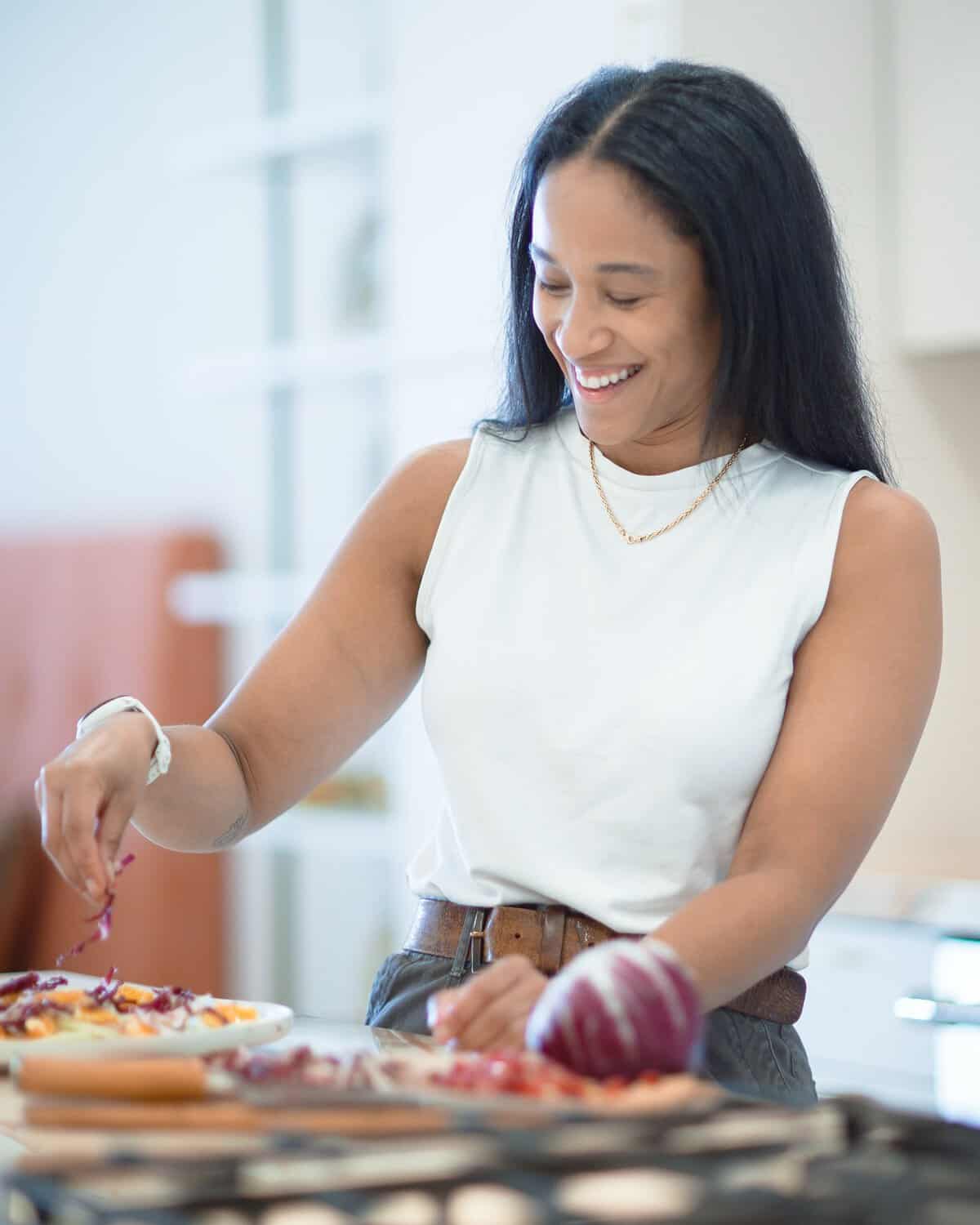 Nicole Lee, Food Network champion and founder of Eats by Nicole, plating a salad in a Los Angeles home kitchen