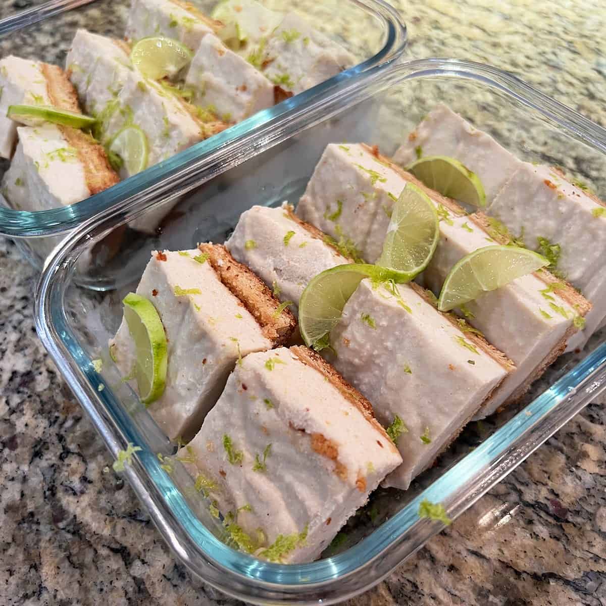 Lime bars with fresh zest portioned into a glass container