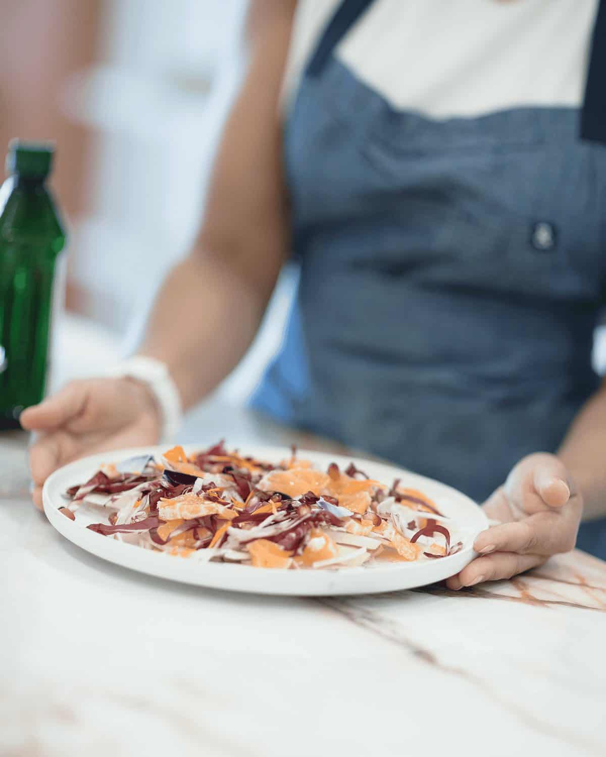 An Eats by Nicole private chef presenting a finished salad in an Orange County home kitchen