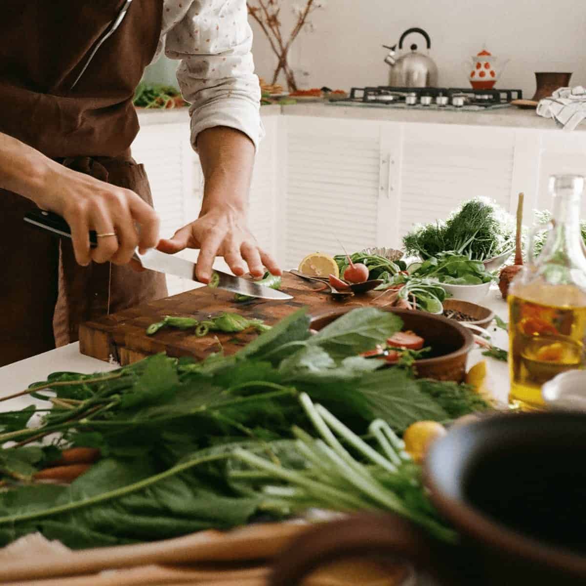 Fresh greens being chopped on a wooden board