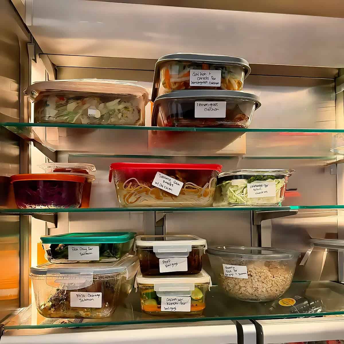 A client refrigerator stocked with labeled glass containers of prepared meals