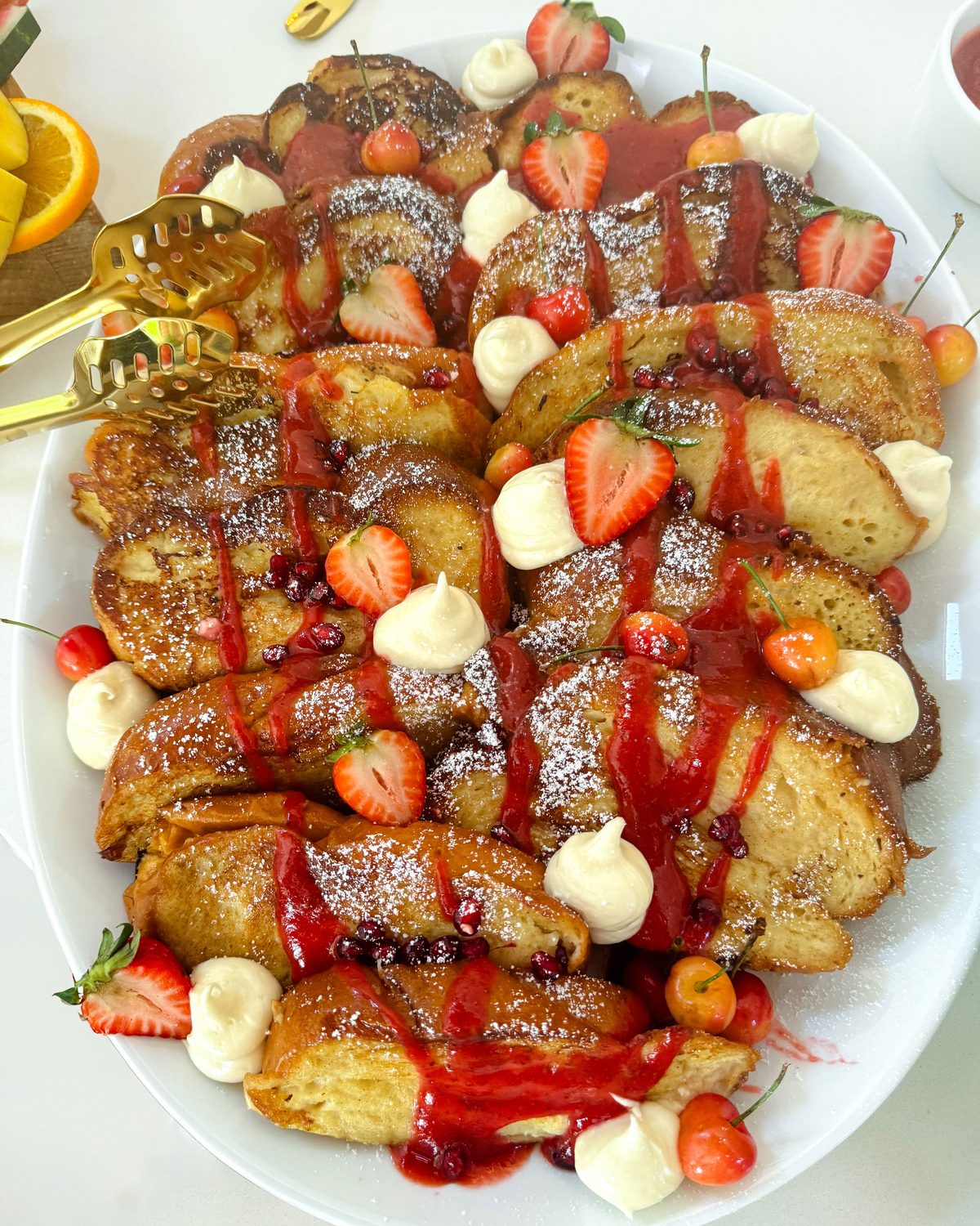 Brunch platter of French toast with strawberries, cherries and whipped cream