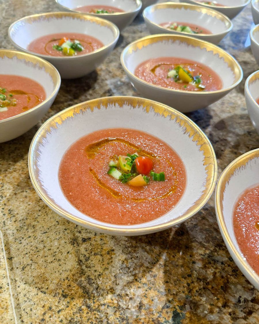 Bowls of chilled gazpacho plated for a dinner party course